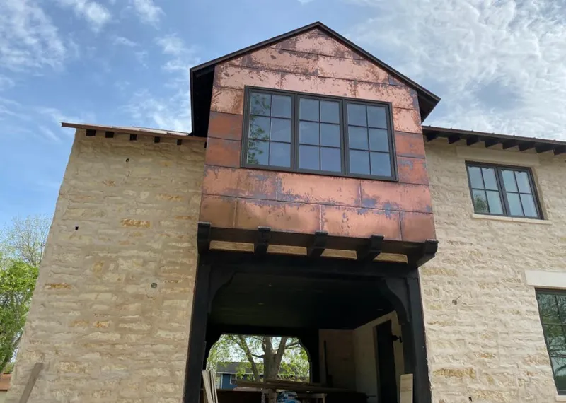 Copper metal panel facade on a stone building for Skylight Installation in Economy