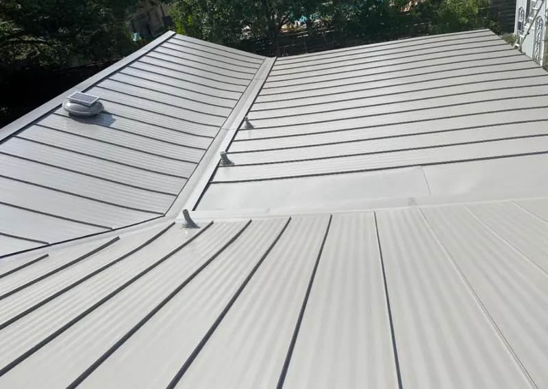 Solar attic fan installed on a metal roof for Roof Ventilation in Economy